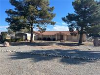 Single story home with landscaped yard and a fire pit at 2891 Oakleaf Ave, Pahrump, NV 89048