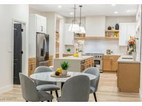 Modern kitchen with island, stainless steel appliances, and light wood cabinets at 62 Incline Village Ct, Henderson, NV 89074