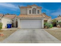 Two-story house with a white garage door and desert landscaping at 7214 Paradise Bay Dr, Las Vegas, NV 89119