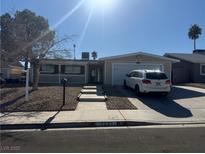 Single-story home with a two-car garage and well-maintained landscaping at 7221 Tempest Pl, Las Vegas, NV 89145