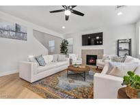 Bright living room features a ceiling fan, fireplace, and comfortable seating around a wooden coffee table at 9625 Ponderosa Skye Ct, Las Vegas, NV 89166