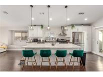 Modern kitchen with white cabinets, quartz countertops, and a large island at 1308 Royal Creek Ct, North Las Vegas, NV 89031