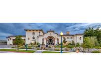 Elegant stucco home boasts a tiled roof, arched entryway, manicured landscaping, and lush greenery at 1616 Villa Rica Dr, Henderson, NV 89052
