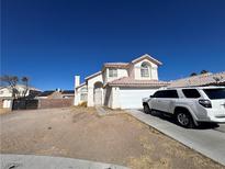 Charming two-story home featuring a two-car garage and a desert landscaped yard under a clear blue sky at 2206 Farmouth Cir, North Las Vegas, NV 89032