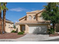 Two-story house with tan exterior, solar panels, and a two-car garage at 2412 Twin Flower Cir, Las Vegas, NV 89134