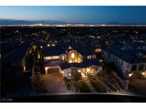 Night view of luxury home with city lights in background at 30 Olympia Outlook Dr, Las Vegas, NV 89141