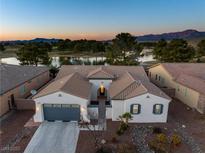 Stunning single-story home boasts a tile roof, desert landscaping, and a serene water view with a golf course backdrop at 5130 Agio Ave, Pahrump, NV 89061