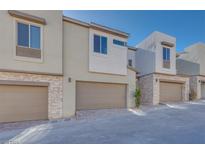 Modern townhome exterior with attached garage and stone accents at 11935 Glide Reflection Ave, Las Vegas, NV 89138