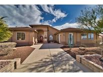 Single-story house with a terracotta roof, landscaped yard, and a paved walkway at 2221 E Winery Rd, Pahrump, NV 89048