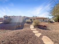 Single-story home with stone pathway, desert landscaping, and a spacious front yard at 311 E Desert Rose Dr, Henderson, NV 89015