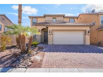 Two-story tan home with a tile roof, desert landscaping, and a brick driveway leading to a two-car garage at 3517 Colby Creek Ave, North Las Vegas, NV 89081