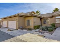 Tan stucco house with tile roof, attached garage, and landscaped walkway at 4773 Big Draw Dr, North Las Vegas, NV 89031