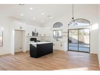 Modern kitchen with island, white cabinets, and stainless steel appliances at 6304 Tanzanite Ave, Las Vegas, NV 89130