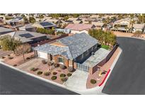 Single-story house with a gray tile roof, landscaping, and a large driveway at 6692 Radiant Red Ave, Las Vegas, NV 89130