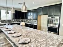 Modern kitchen with granite countertops and dark cabinetry at 6692 Radiant Red Ave, Las Vegas, NV 89130