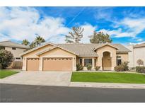 Single-story house with three-car garage and landscaped lawn at 2424 Ping Dr, Henderson, NV 89074