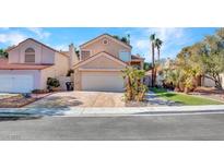Tan two-story house with a two-car garage and landscaped yard at 3257 Coral Harbor Dr, Las Vegas, NV 89117