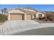 Beige house with two-car garage and landscaped yard at 3828 Terrace Grove St, Las Vegas, NV 89129