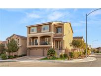 Two-story home with a three-car garage, balcony, desert landscaping, and a mix of stone and stucco facade at 6595 Creekside Cellars Ct, Las Vegas, NV 89139