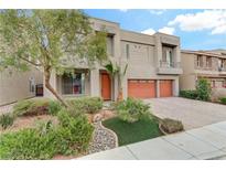 Two-story house with orange garage doors and landscaped front yard at 9792 Russian Hill St, Las Vegas, NV 89141