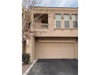 Tan two-story townhome with attached garage and balcony at 10550 W Alexander Rd # 2082, Las Vegas, NV 89129