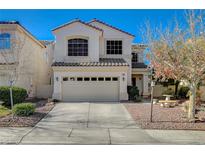 Two-story house with tan exterior, two car garage, and landscaping at 1805 Grand Rodeo St, Las Vegas, NV 89117