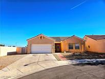 Tan one-story house with a two-car garage and desert landscaping at 3538 Canter Dr, North Las Vegas, NV 89032