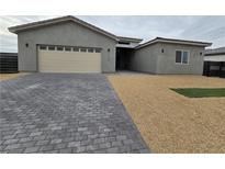 Modern single-story home with neutral exterior and paver driveway at 1770 Ironside St, Pahrump, NV 89048