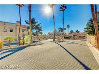 View of the community entrance with secured gate and desert landscaping at 2983 Juniper Hills Blvd # 102, Las Vegas, NV 89142