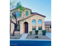 Two-story house with a tan exterior, brown door, and landscaped front yard at 968 Lucky Bamboo Dr, Henderson, NV 89052