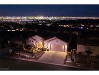 Night view of single-story house with city skyline in background at 2214 Brighton Point Ave, Henderson, NV 89044