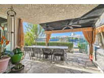 Spacious covered patio with lake view, dining table, and ceiling fans at 2625 Seashore Dr, Las Vegas, NV 89128