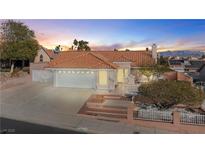 Charming single-story home with a tile roof, two-car garage, and landscaped front yard at sunset at 3280 James A Bilbray Pkwy, Laughlin, NV 89029