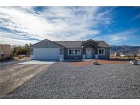 Charming single-story home featuring a two-car garage, gravel yard, and well-maintained front lawn at 3960 Dart Dr, Pahrump, NV 89060