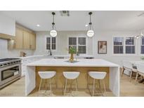 Modern kitchen with island, stainless steel appliances, and light wood cabinets at 517 Annet St, Henderson, NV 89052