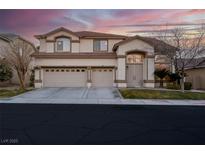 Two-story tan home with a two-car garage and well-maintained landscaping at 553 Sinfold Park St, Las Vegas, NV 89148
