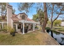 Relaxing patio with pergola, overlooking a peaceful canal at 6973 Emerald Springs Ln, Las Vegas, NV 89113