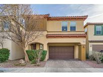 Tan two-story house with brown garage door and landscaping at 8477 Orly Ave, Las Vegas, NV 89143