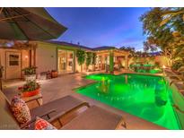 Stunning backyard oasis with a sparkling pool, lush landscaping, and inviting patio at 10414 Hemingway Ct, Las Vegas, NV 89149