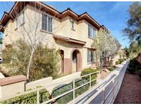 Tan two-story townhome with walkway and landscaping at 3820 Wiggins Bay St # 201, Las Vegas, NV 89129