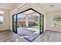 Bright living space features hardwood floors and a large sliding glass door to the brick patio at 4973 Sandline Ct, Las Vegas, NV 89135