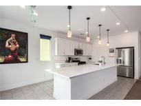 Modern kitchen with white cabinets, quartz countertops, and stainless steel appliances at 6075 Wyndham Estate Ave, Las Vegas, NV 89141