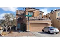 Two-story house with tan exterior, two-car garage, and landscaping at 6864 Armistead St, Las Vegas, NV 89149