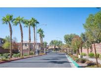 Gated community entrance with palm trees and well-maintained landscaping at 690 Calamus Palm Pl, Henderson, NV 89011