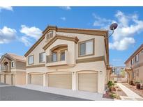 Charming three-story condo with a beige exterior, private balcony, and attached garages at 6345 Dan Blocker Ave # 101, Henderson, NV 89011