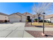 Charming single-story home featuring a well-manicured lawn, desert landscaping and a three car garage at 1595 Cattle Ranch Pl, Henderson, NV 89002