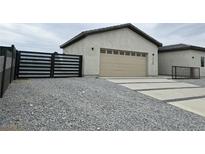 Modern home exterior featuring a two-car garage and a gravel driveway at 1760 Ironside Street St, Pahrump, NV 89048