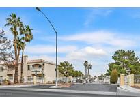 Low angle exterior shot of a multistory condo complex with a gated entrance and mature palm trees at 1900 N Torrey Pines Dr # 112, Las Vegas, NV 89108