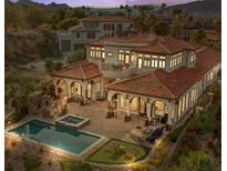 An aerial view of a luxury home featuring a pool, spa, outdoor seating area, and a red tile roof at 22 Rue Grimaldi Way, Henderson, NV 89011