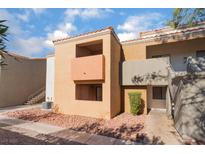 Tan two-story building with Spanish tile accents, showing a walkway and landscaping at 3151 Soaring Gulls Dr # 1138, Las Vegas, NV 89128